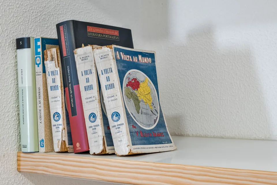 Livros antigos numa prateleira de madeira