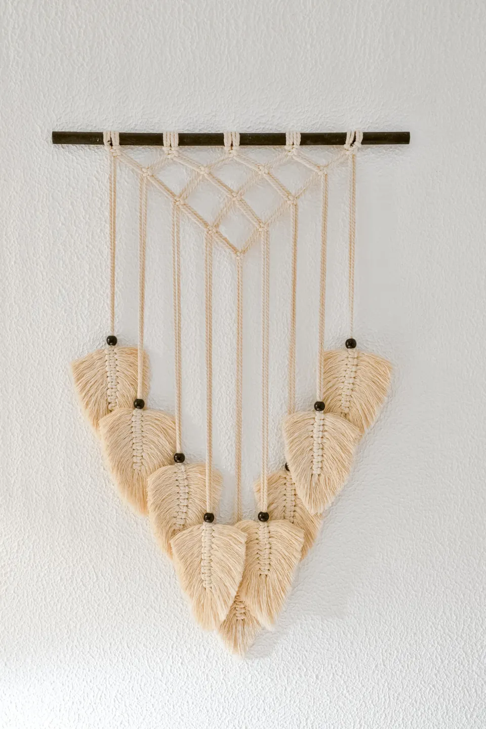 Macramé feito à mão pendurado na parede caiada