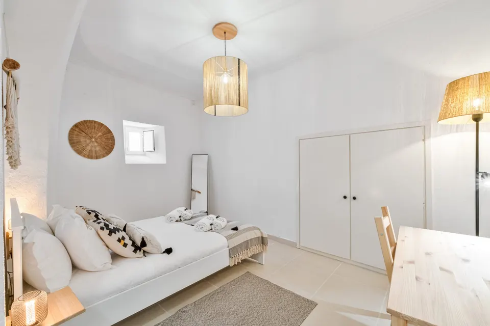Quarto com roupeiro branco embutido e candeeiro de pé